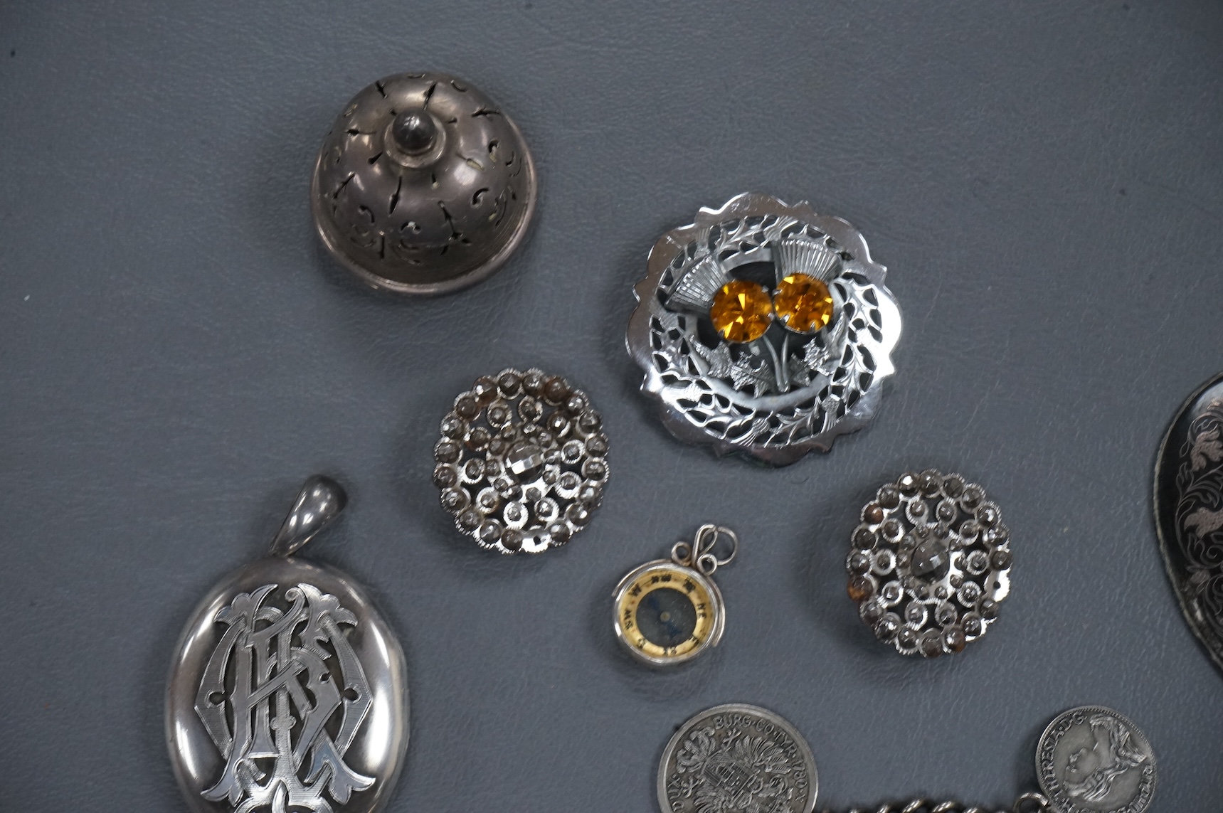 A mixed group of assorted collectables including a silver vesta case, two Victorian white metal lockets, two cut steel buttons, a coin bracelet and three other items.